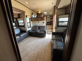 A living room with a couch and chairs in a rv.