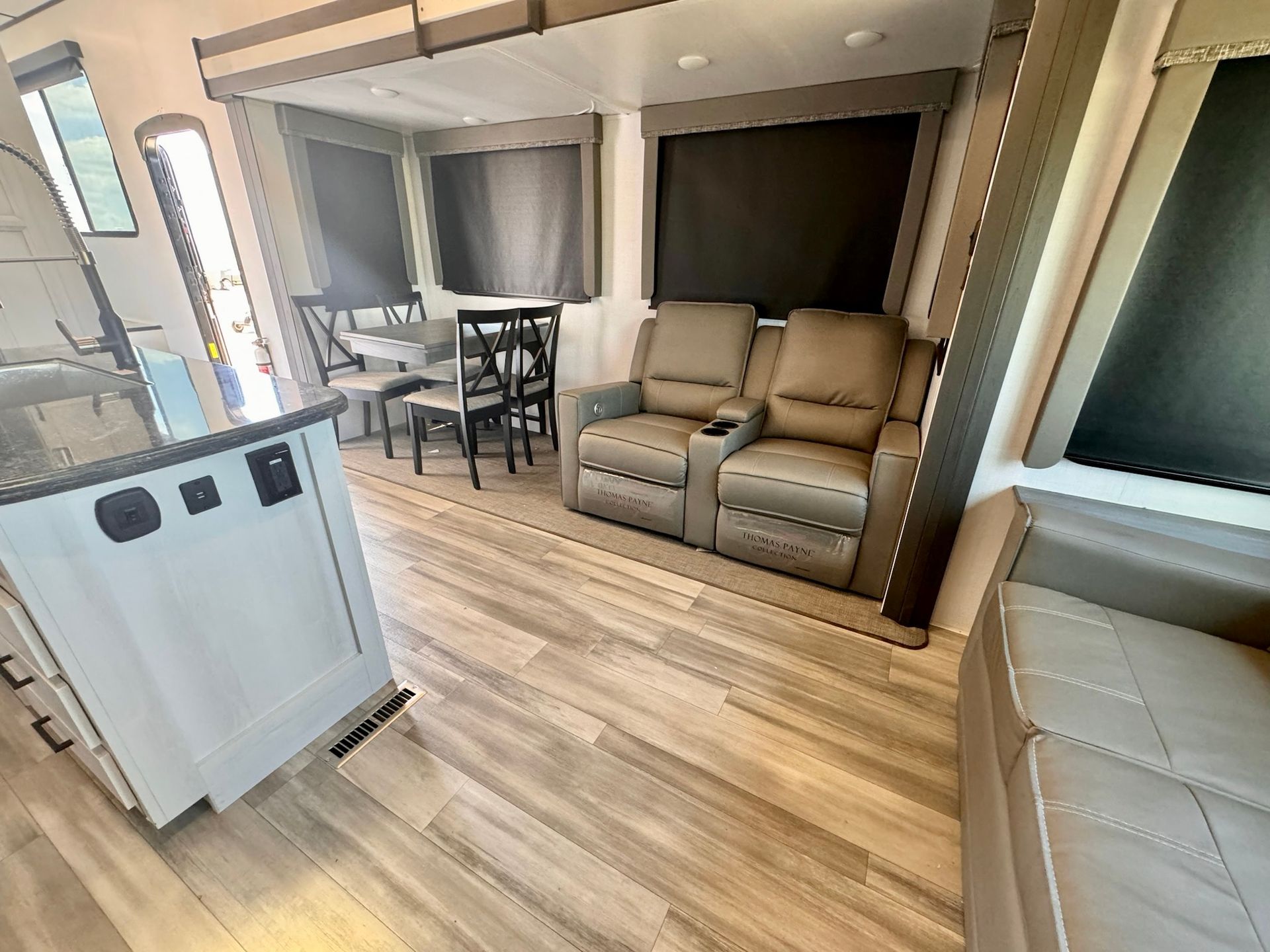 A living room with a couch , chairs and a table.