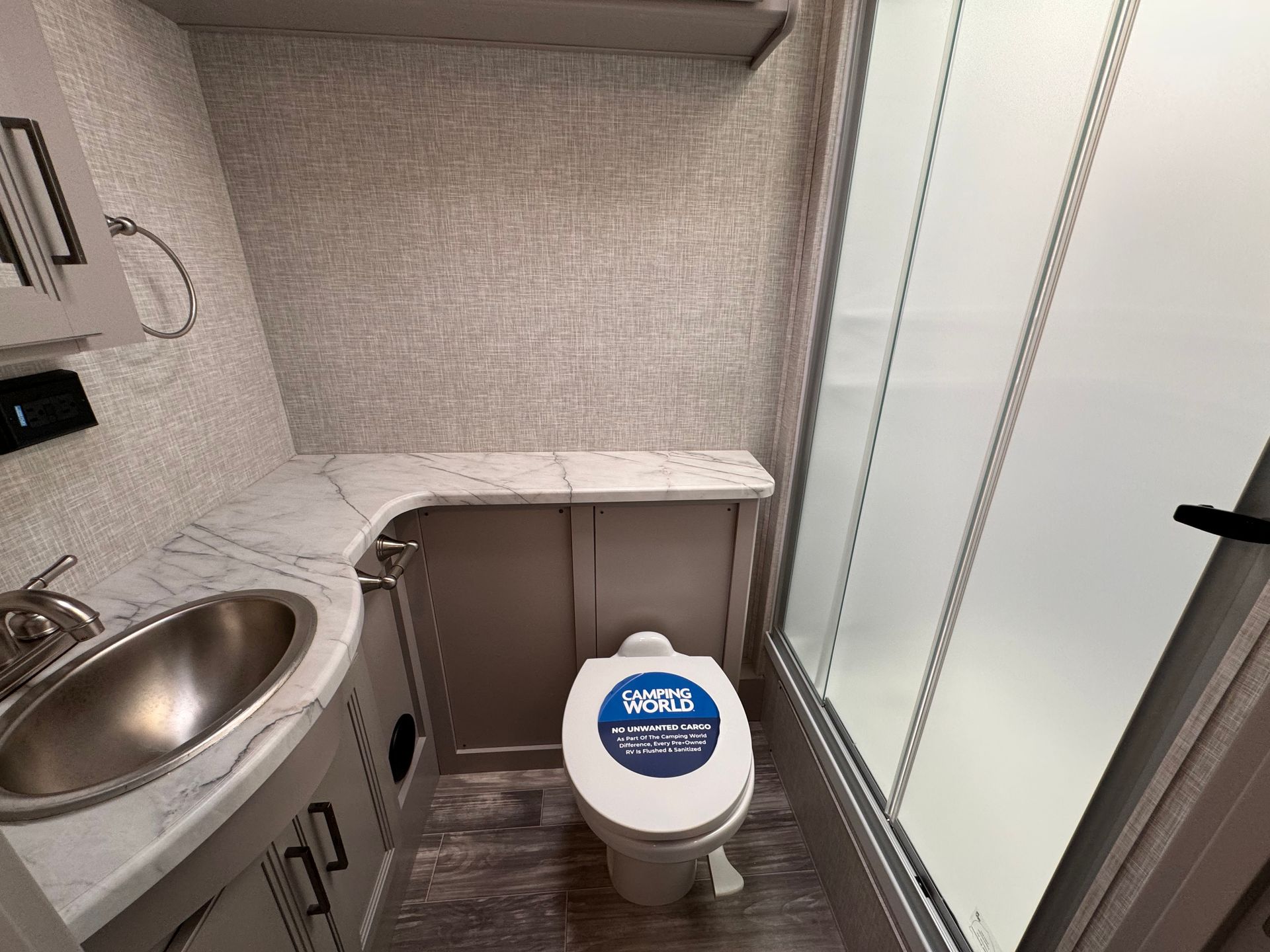 A bathroom with a toilet , sink and shower.