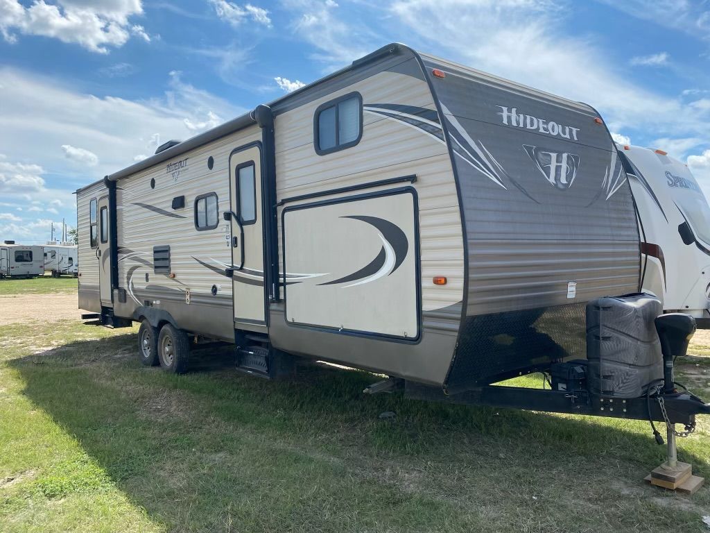 A travel trailer is parked in a grassy field.
