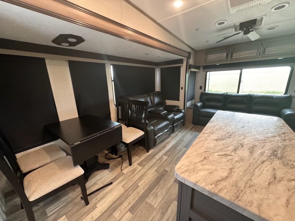 A living room with a couch , table and chairs.