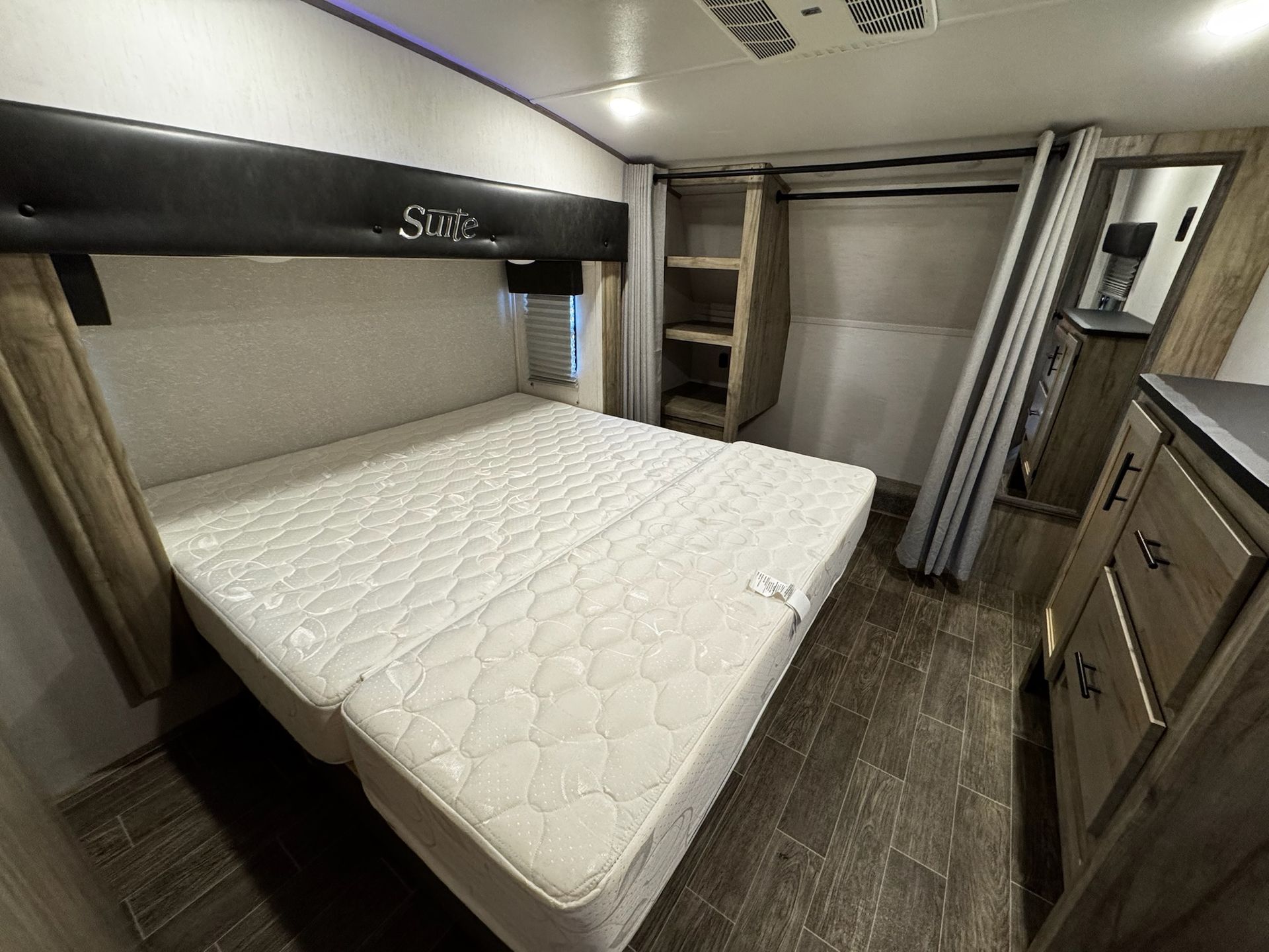 A bedroom in a rv with a bed and a closet.