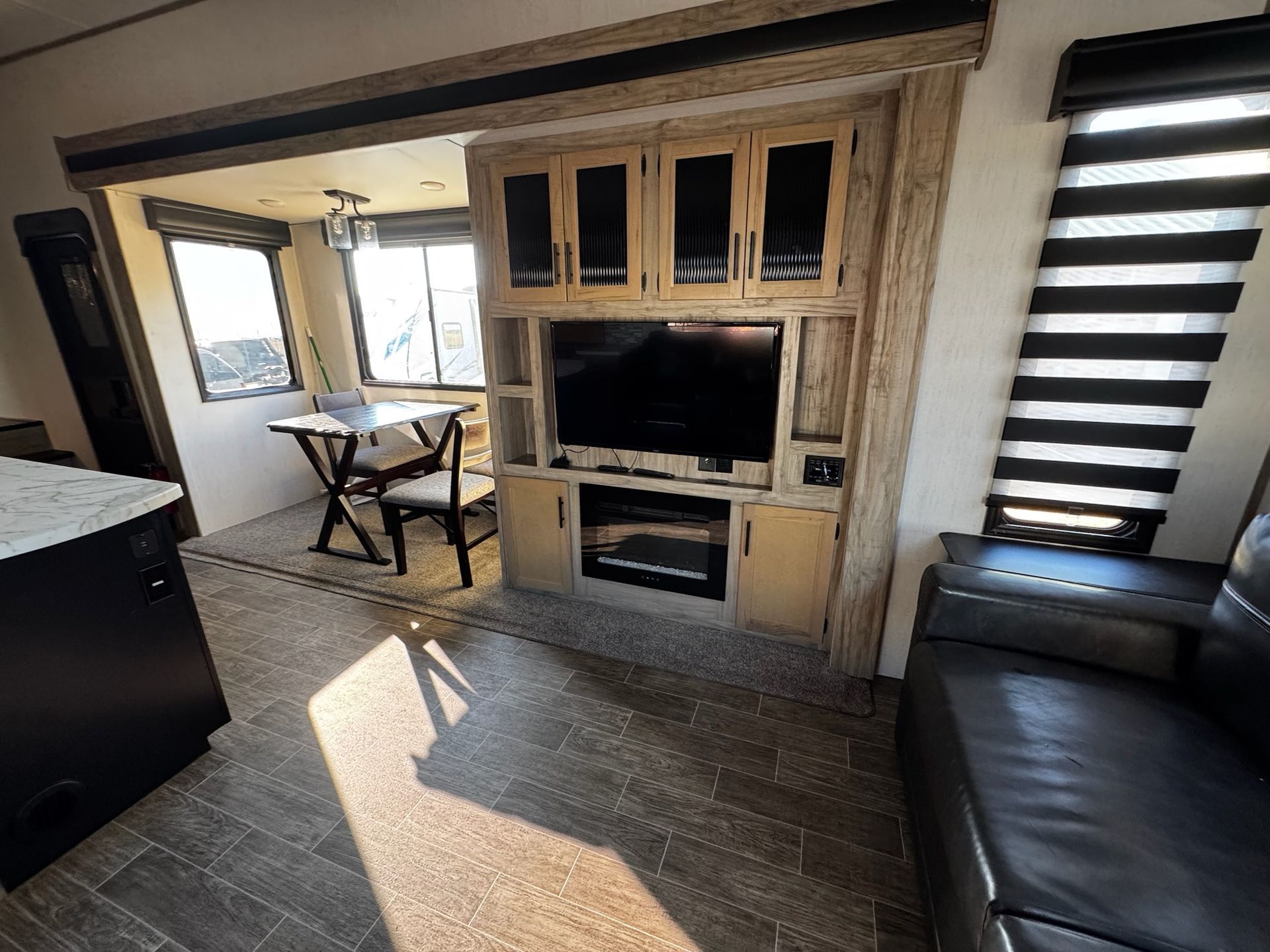 A living room with a couch , table , television and fireplace.