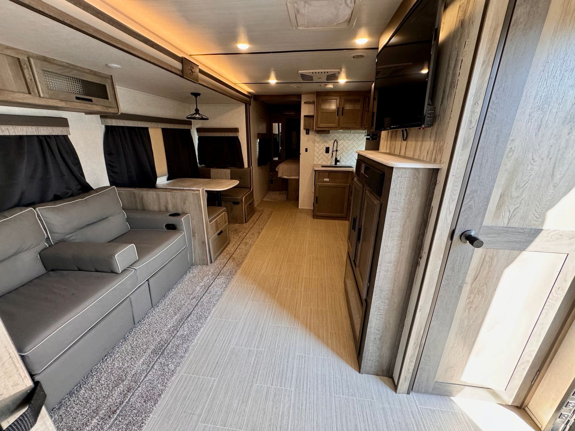 A living room in a rv with a couch and a television.