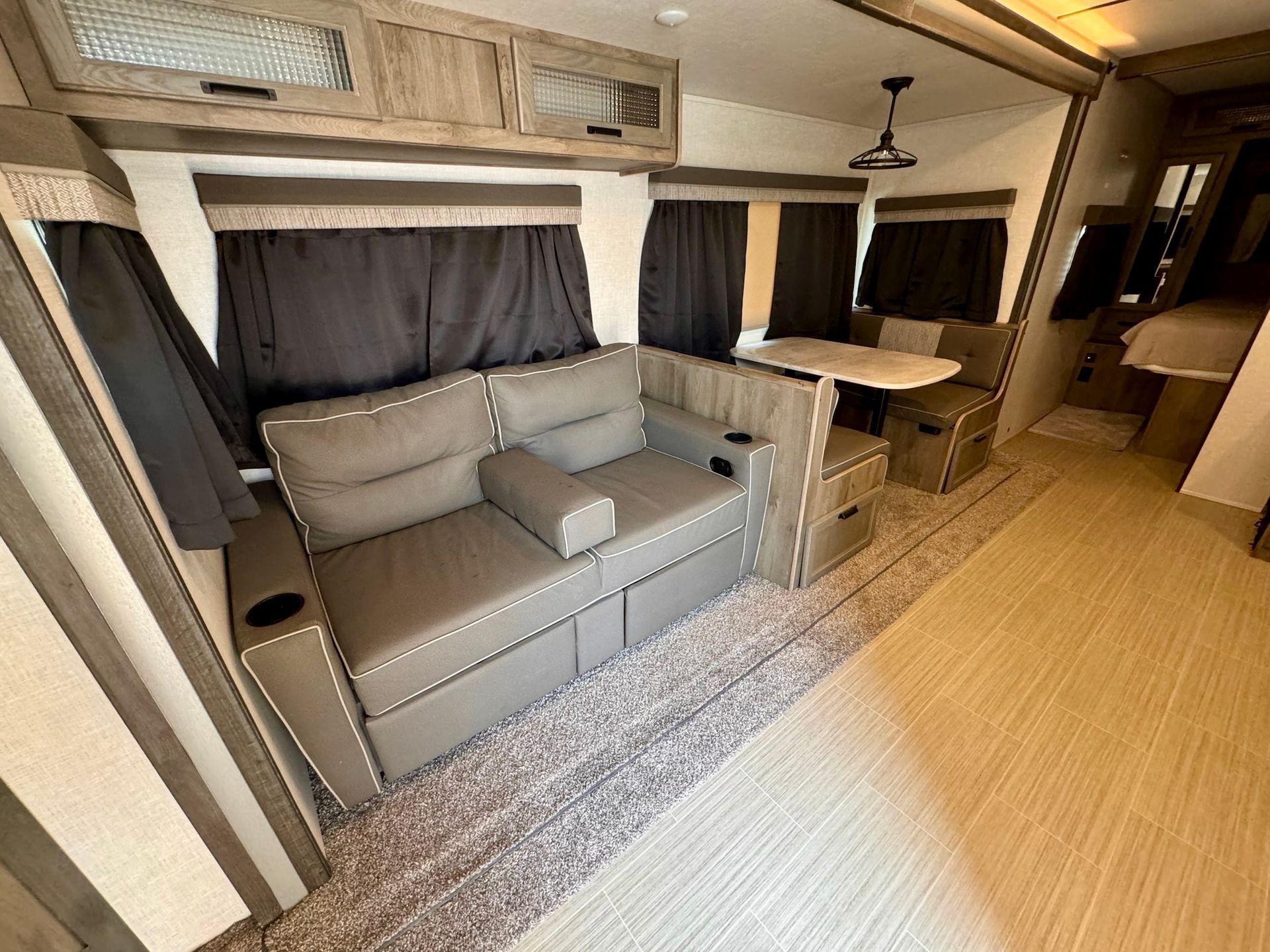 A living room in a rv with a couch and a table.