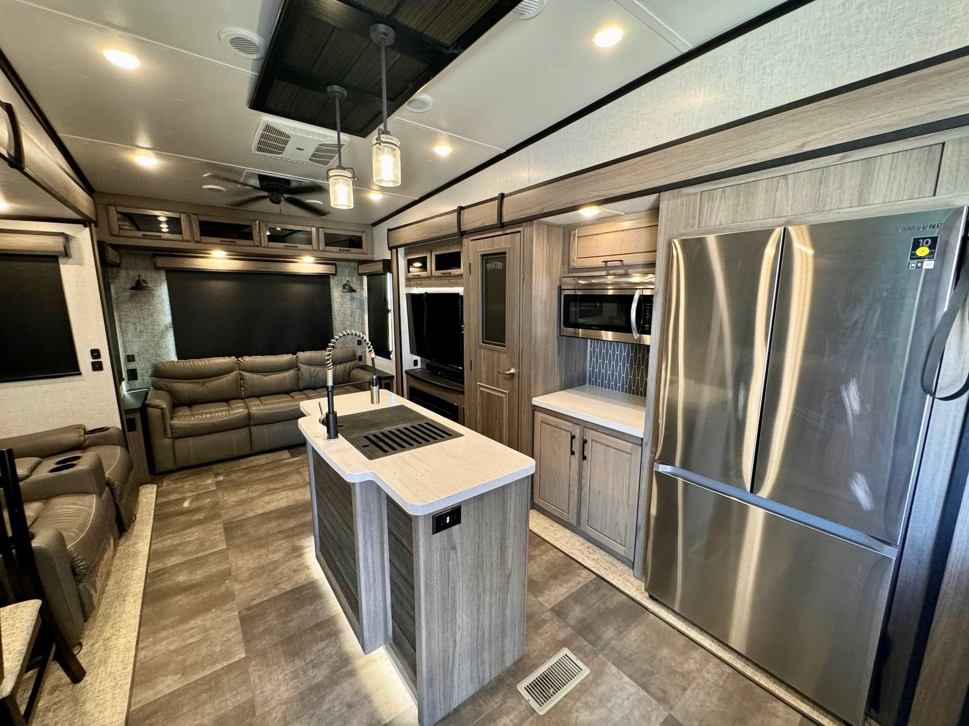 A kitchen in a rv with stainless steel appliances and a large island.
