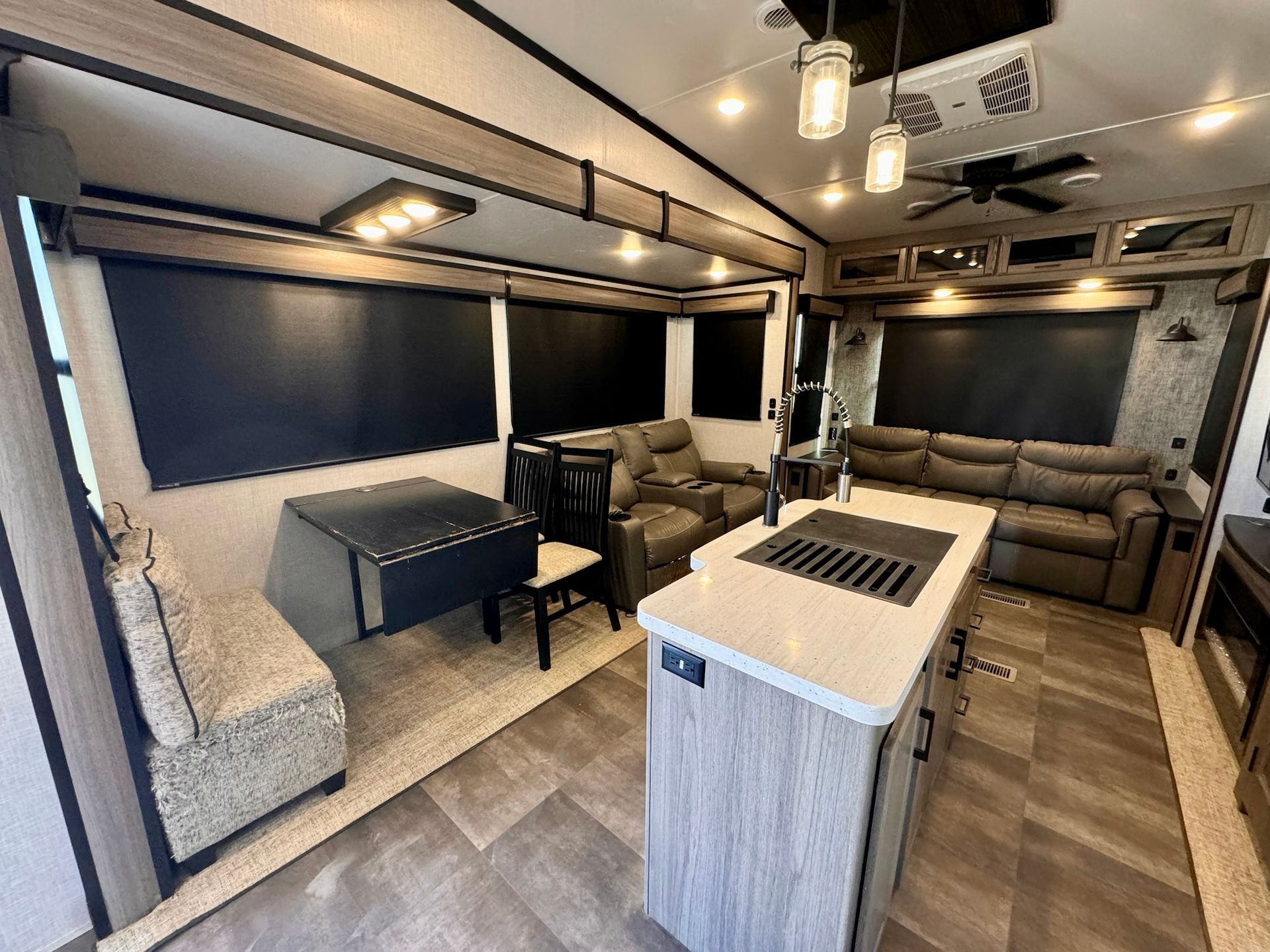 A living room in a rv with a couch , table and chairs.