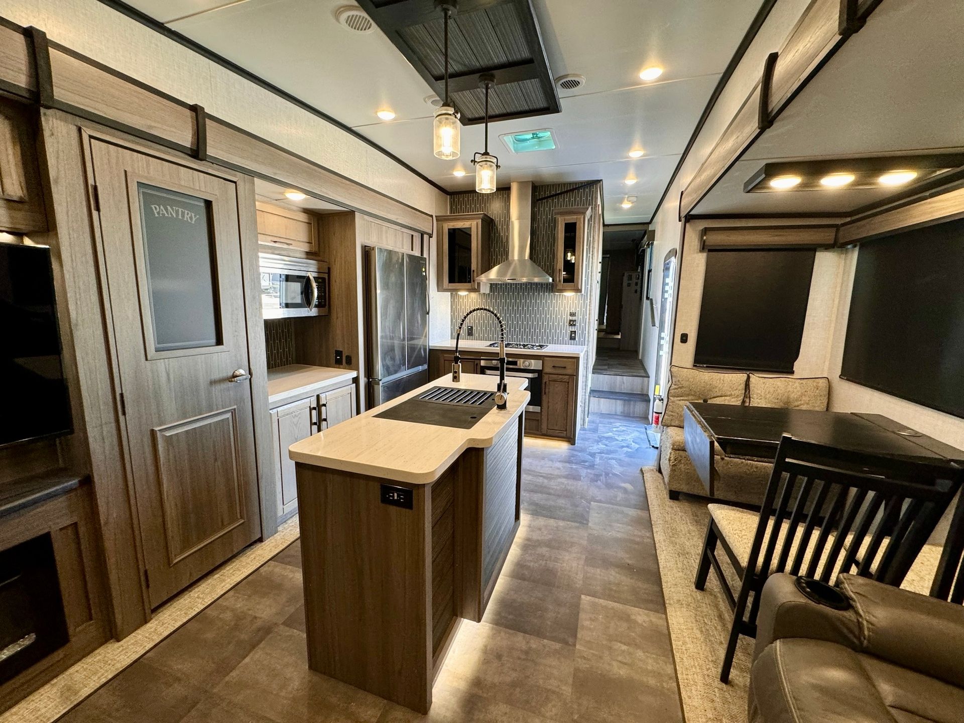 A rv with a kitchen , dining room , and living room.