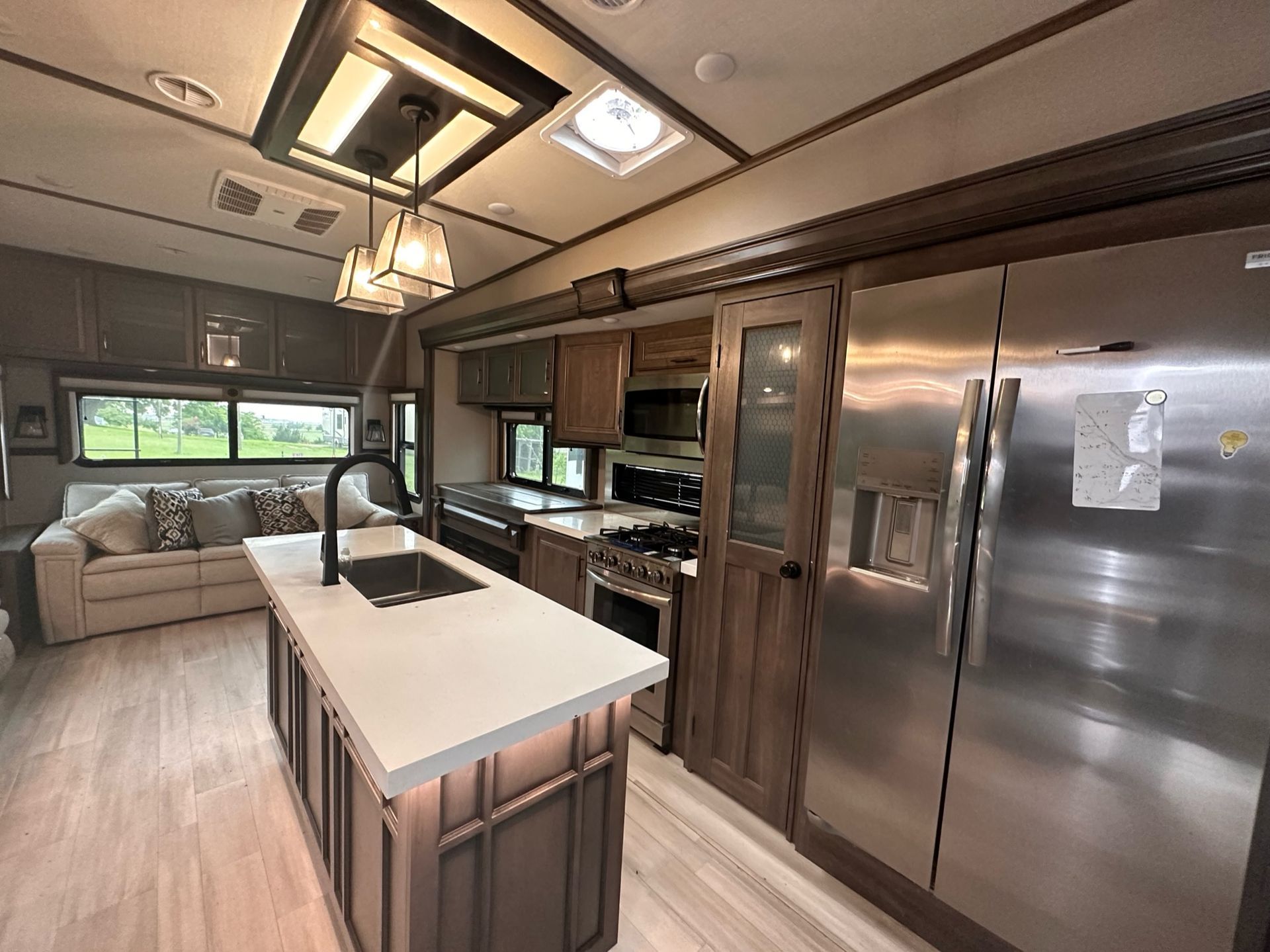 A kitchen in a rv with stainless steel appliances and a large island.
