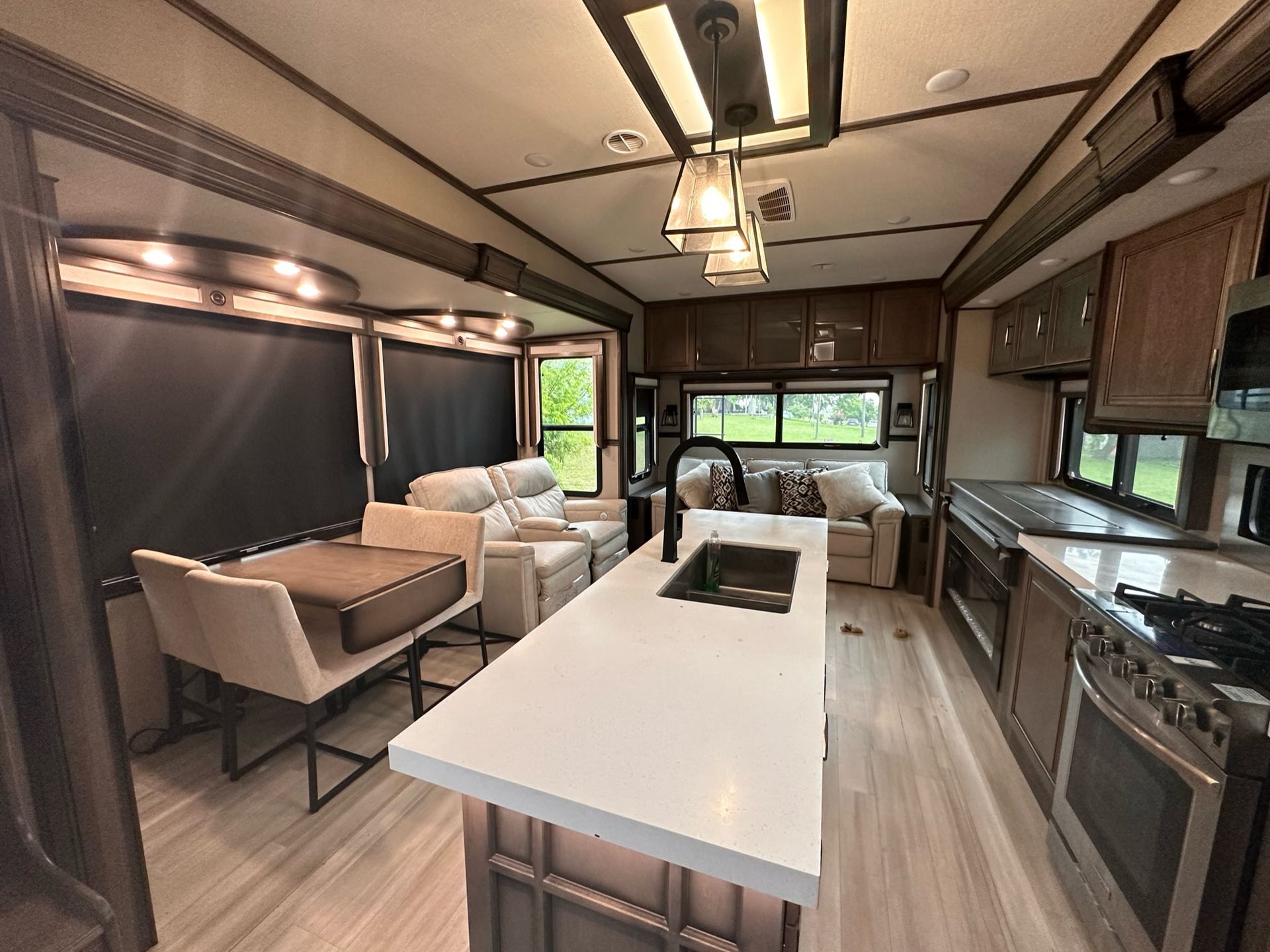 The inside of a rv with a living room and kitchen.