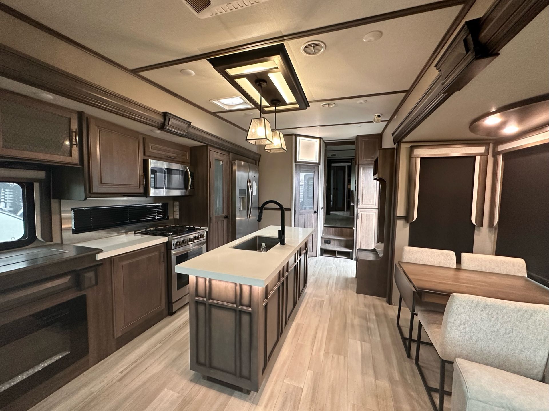A kitchen in a rv with a large island and a table.