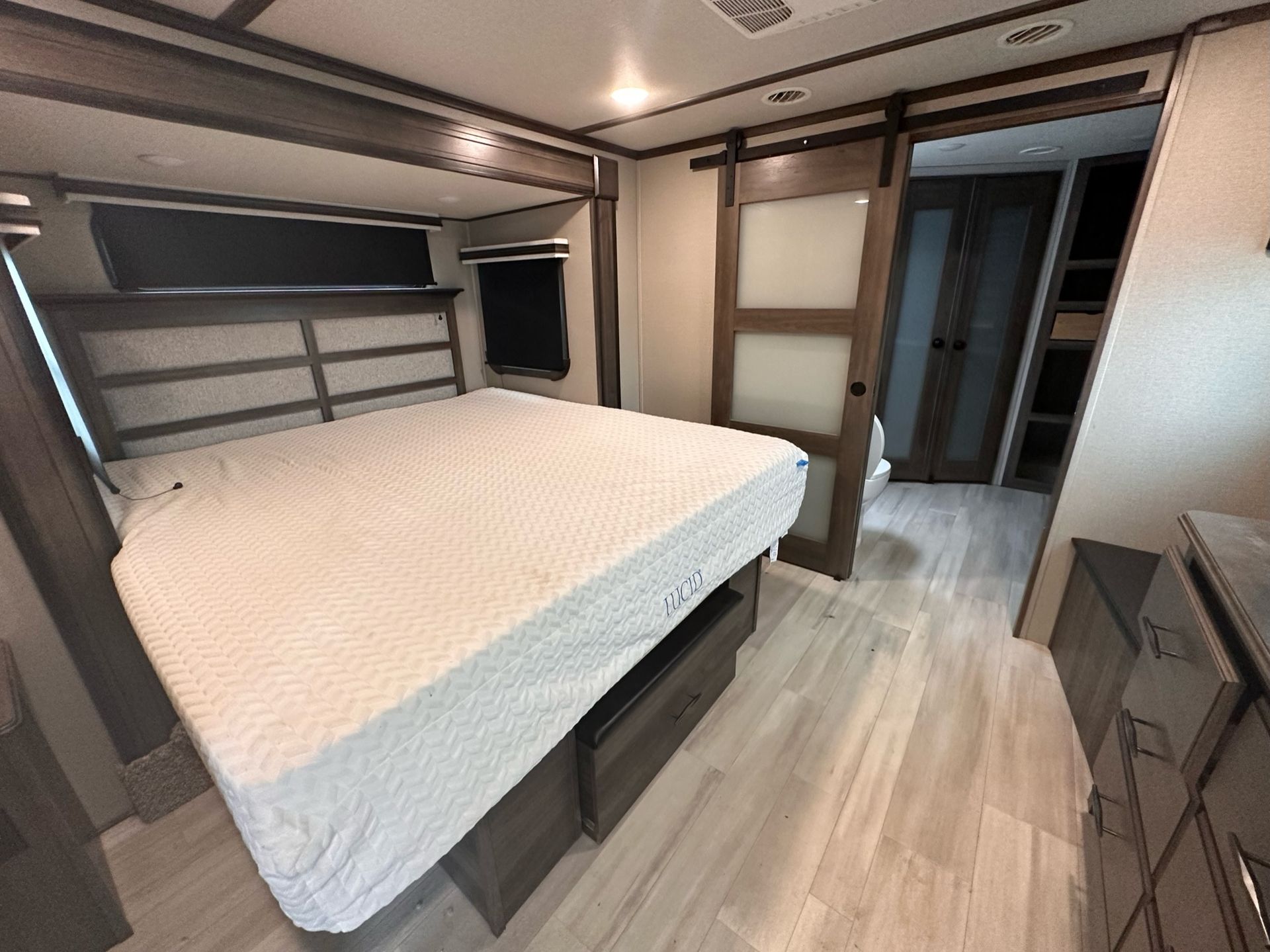 A bedroom with a bed and a sliding barn door.