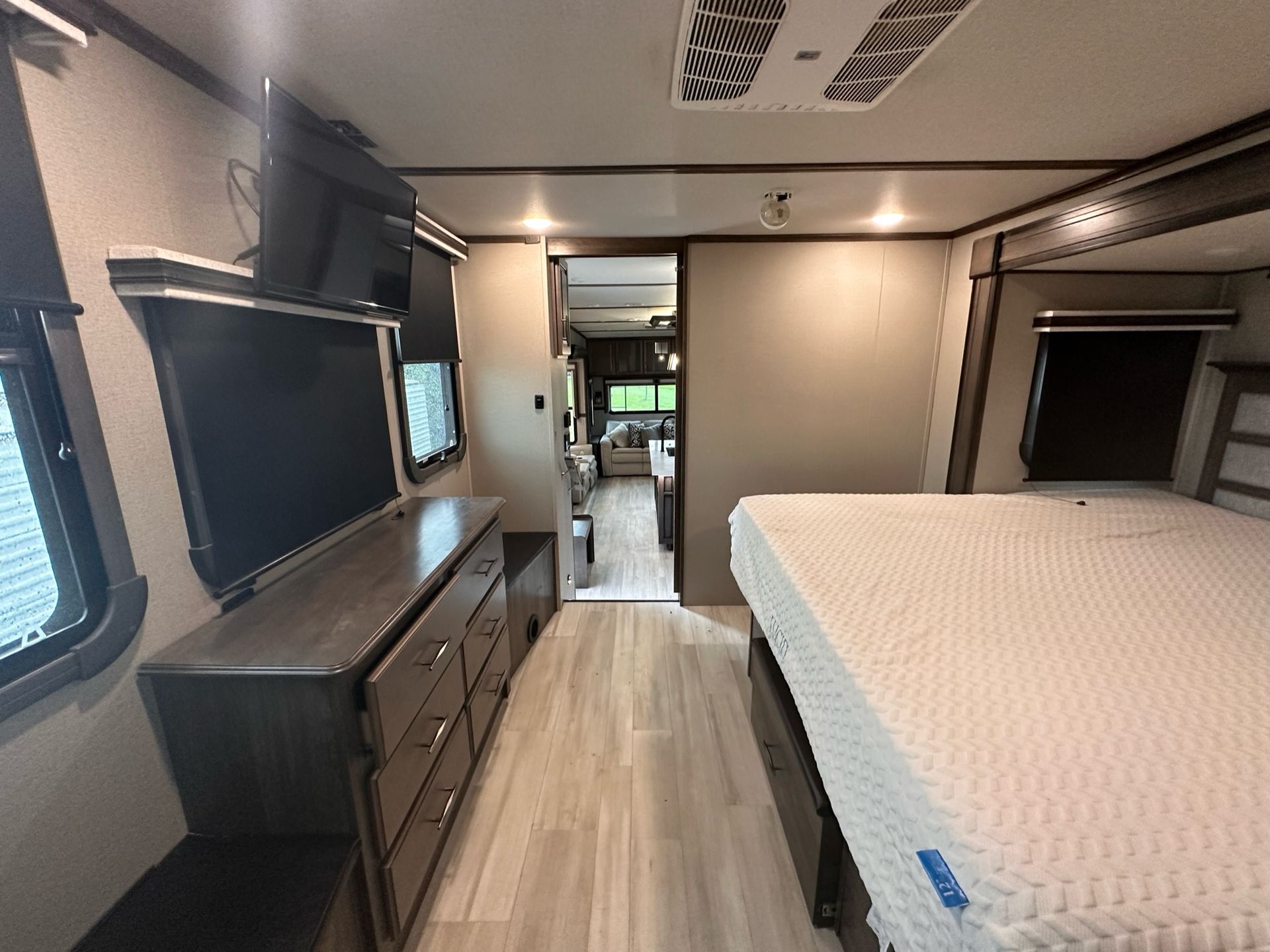 A bedroom in a rv with a bed and a television.
