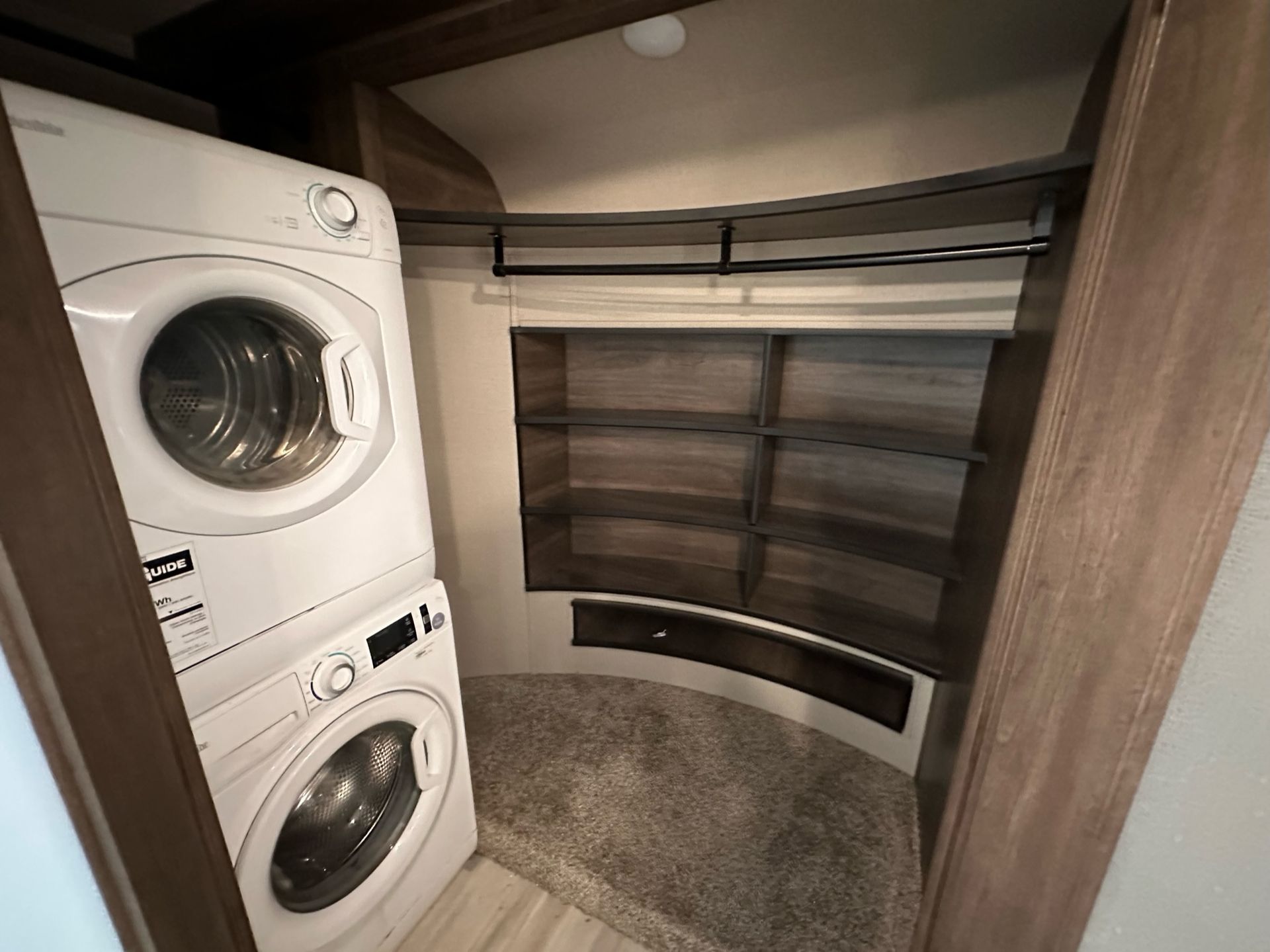 A laundry room with a washer and dryer stacked on top of each other.