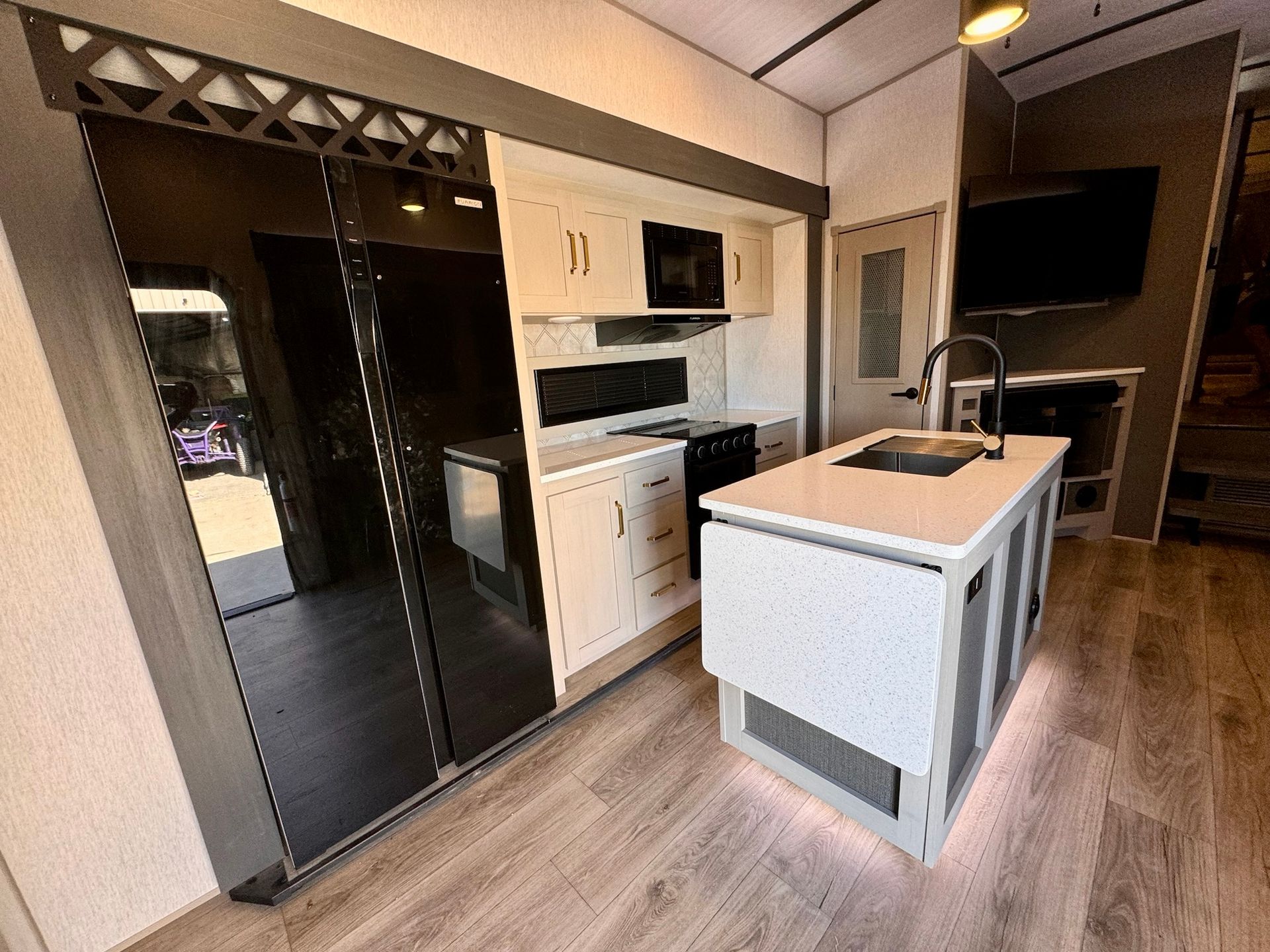 A kitchen with a sink , refrigerator , stove and microwave.