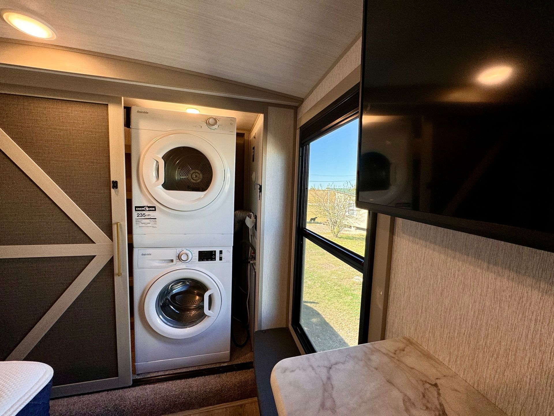 A washer and dryer are stacked on top of each other in a laundry room.