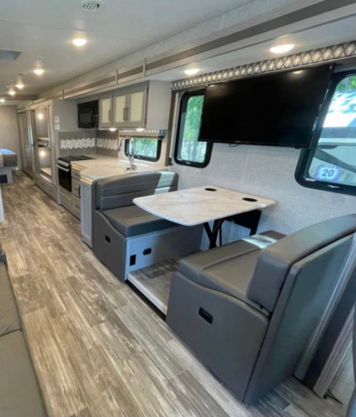 The inside of a rv with a table and chairs.