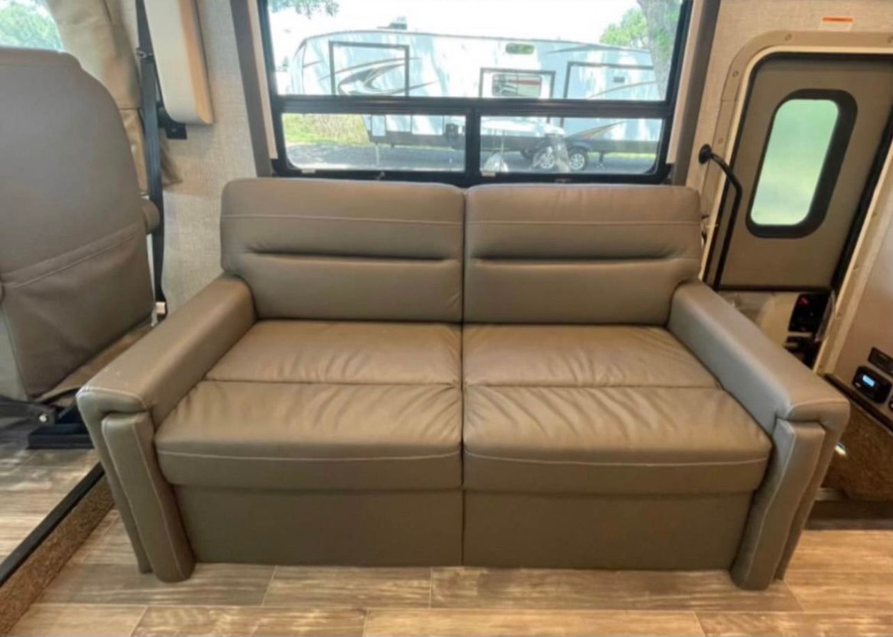 A couch that has been converted into a bed in a rv.