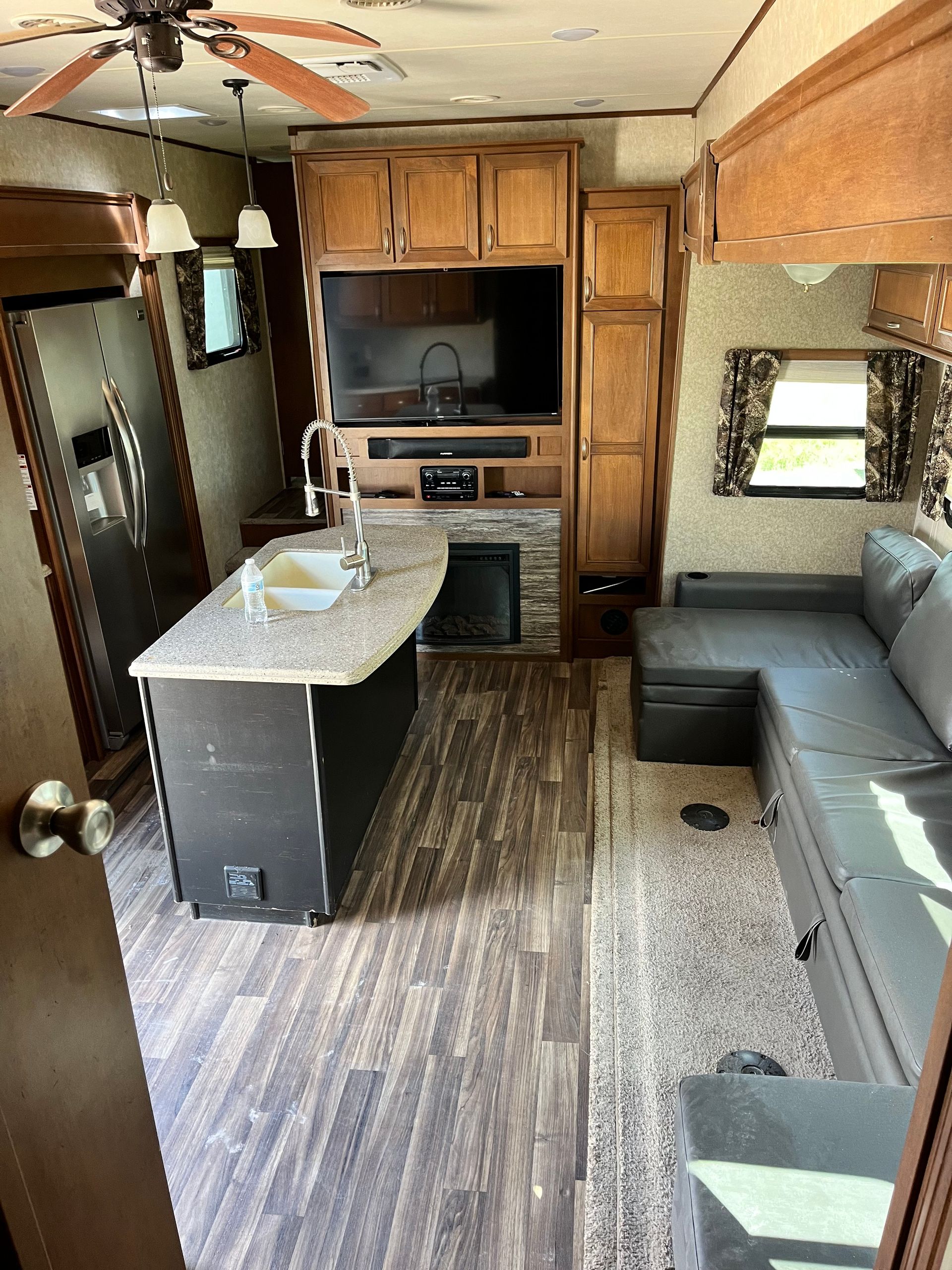 A living room in a rv with a couch and a television.