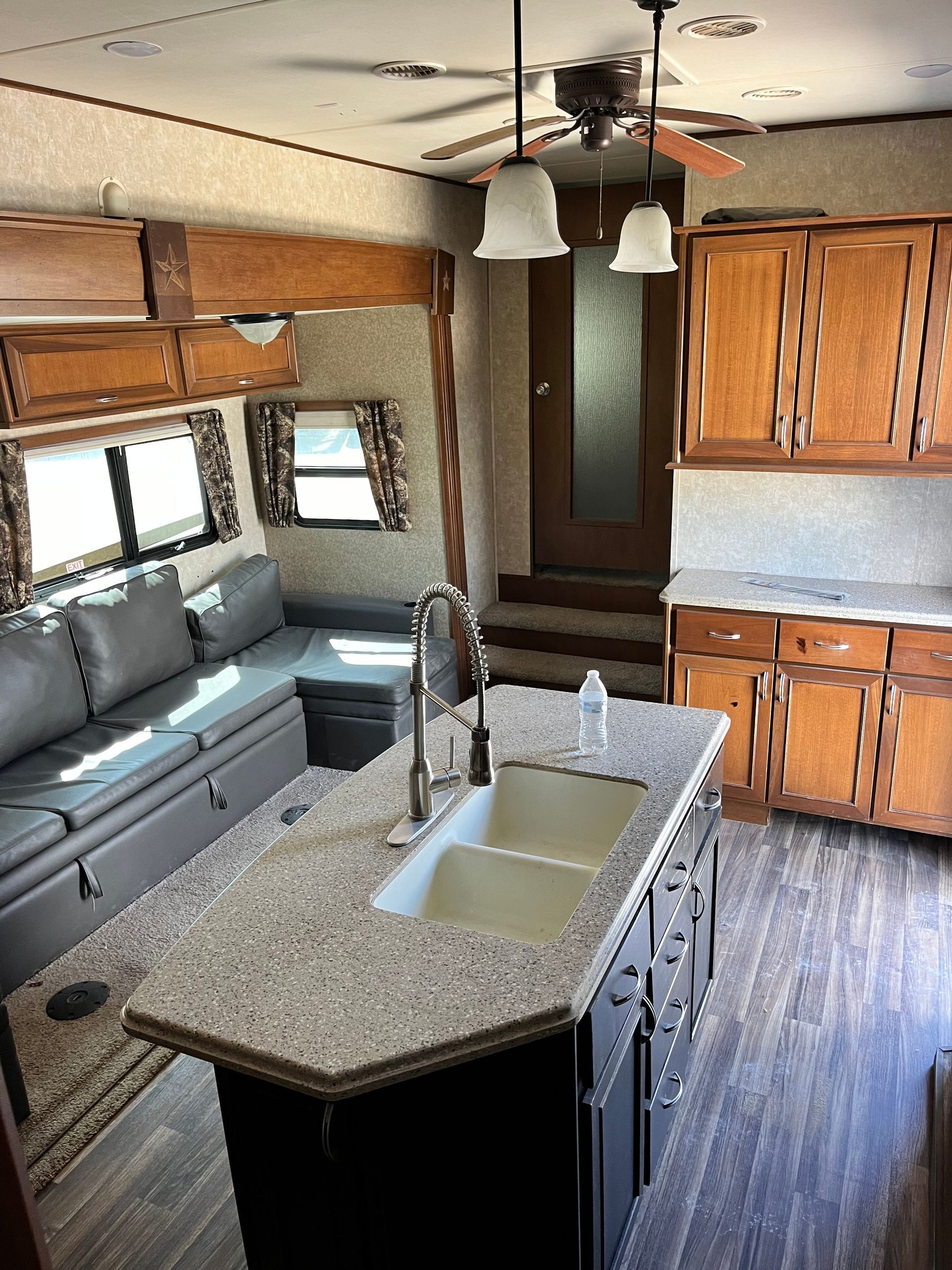 A kitchen with a sink and a couch in it