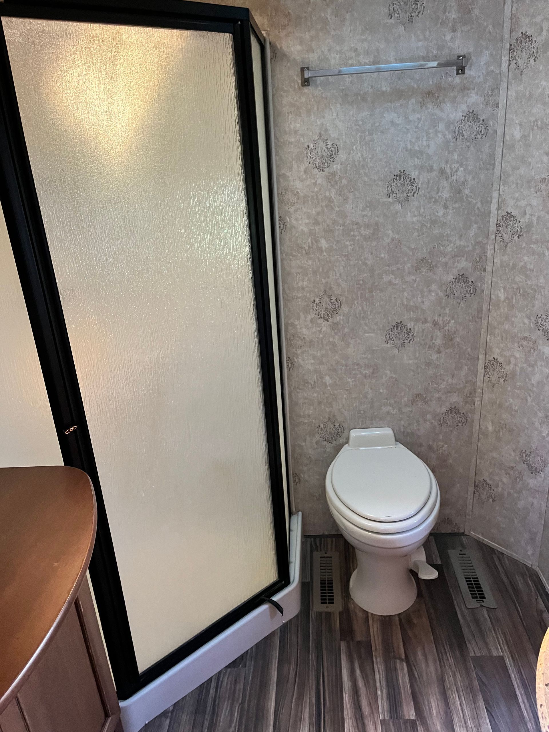 A bathroom with a toilet and a shower stall