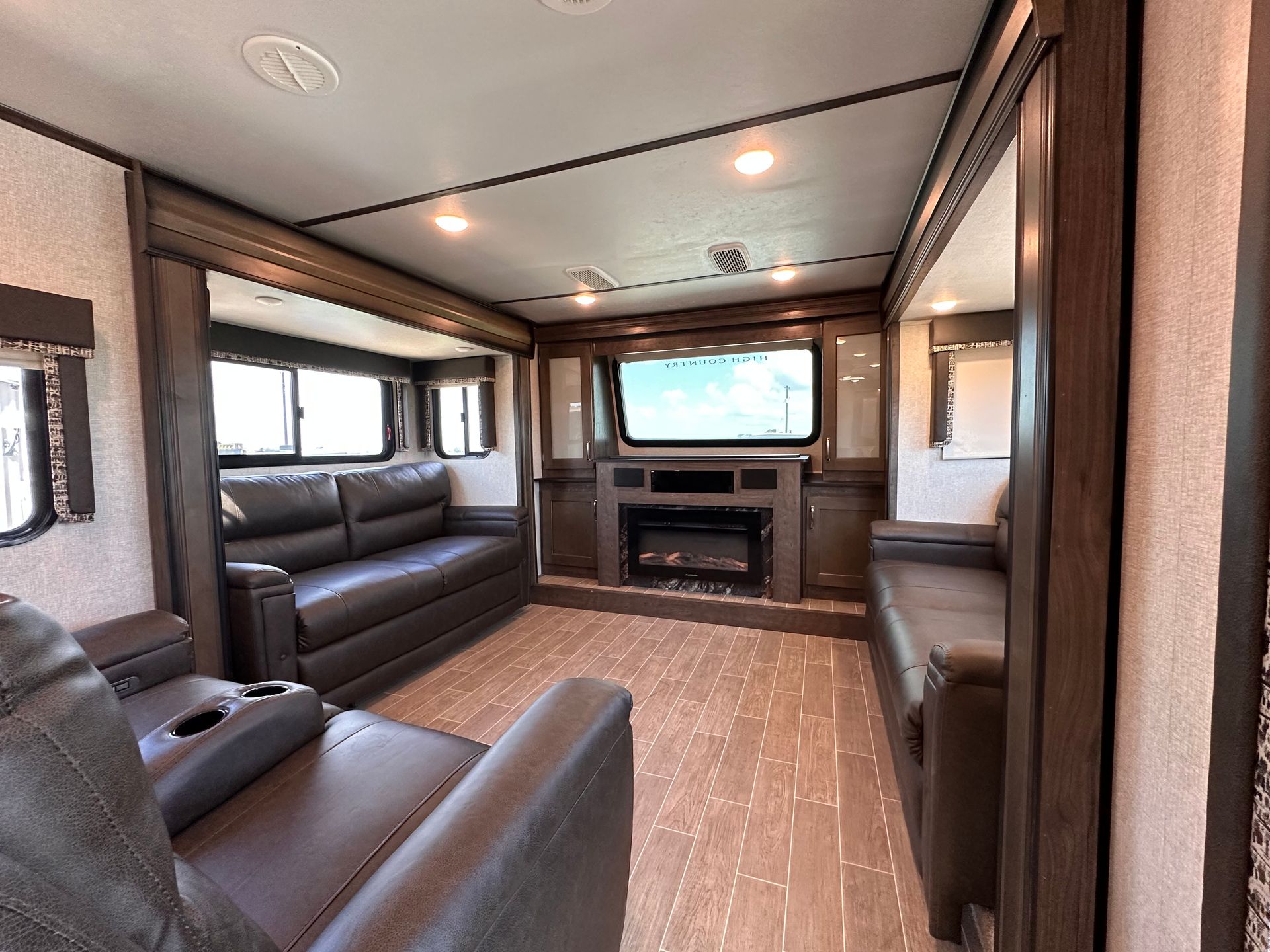 A living room with a couch , chair , fireplace and television.