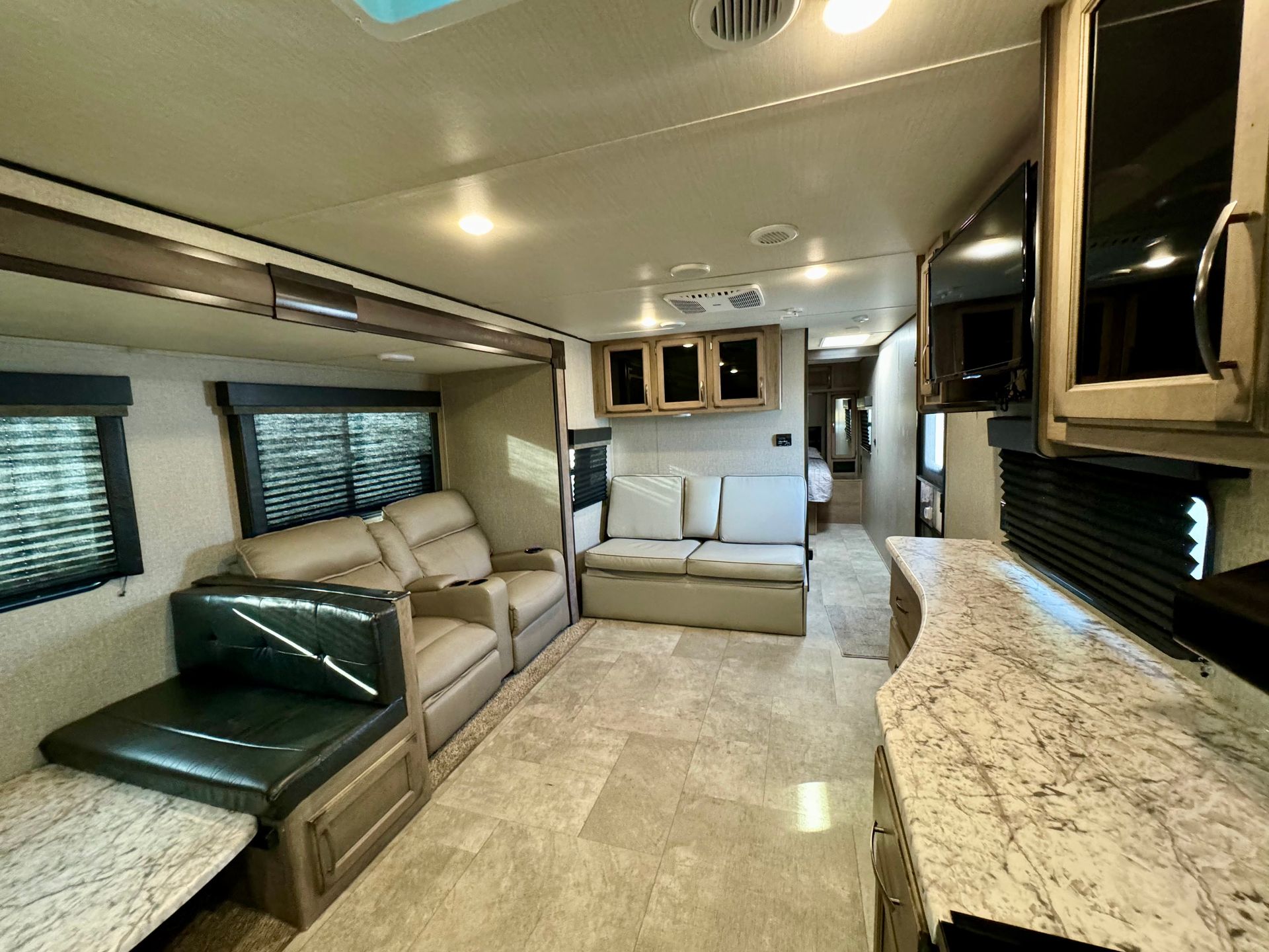 A living room in a rv with a couch and chairs