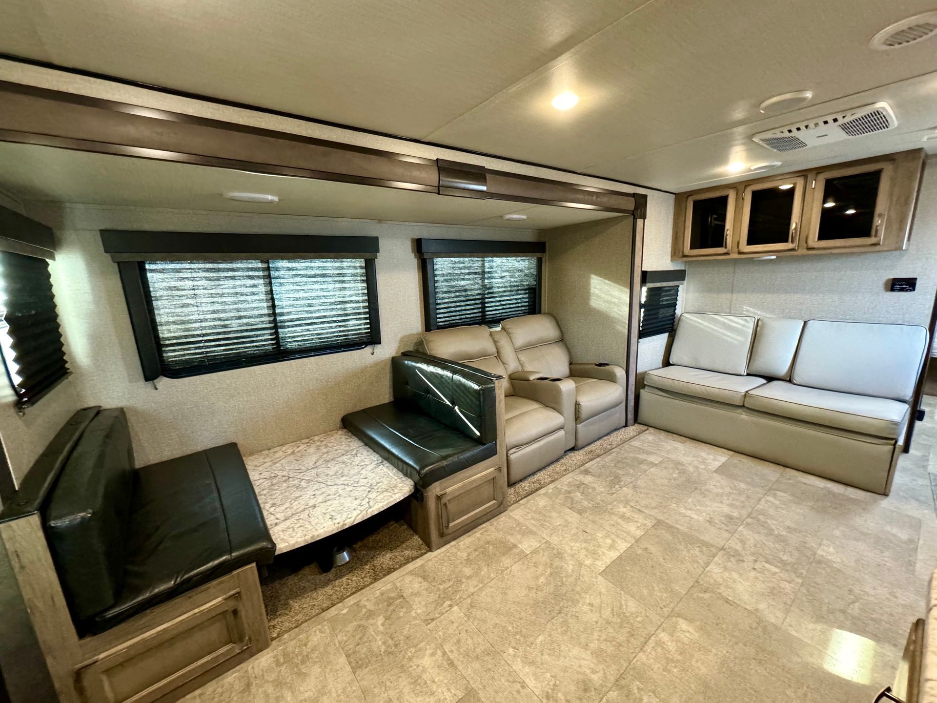 A living room with a couch , chairs , and a table.