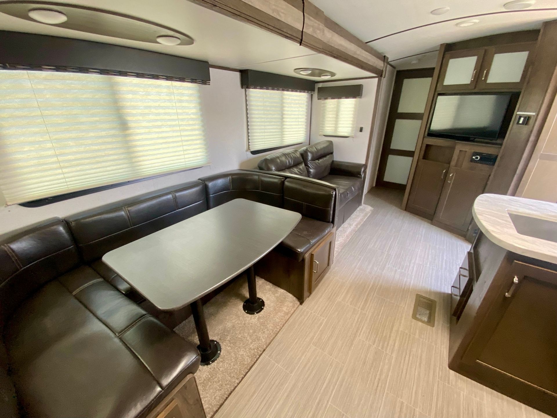 A living room in a rv with a table and couch.