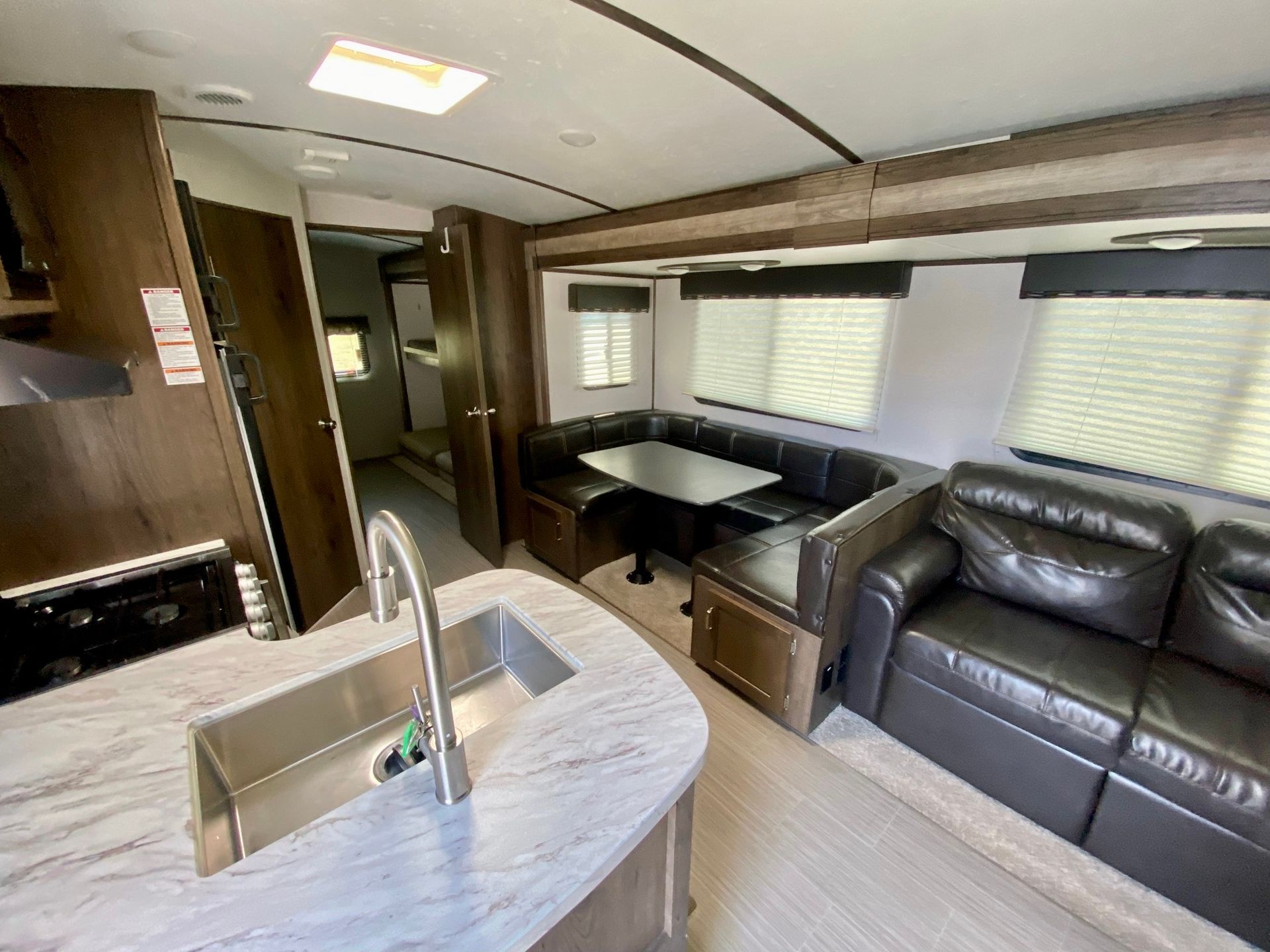 A kitchen with a sink and a couch in a rv.