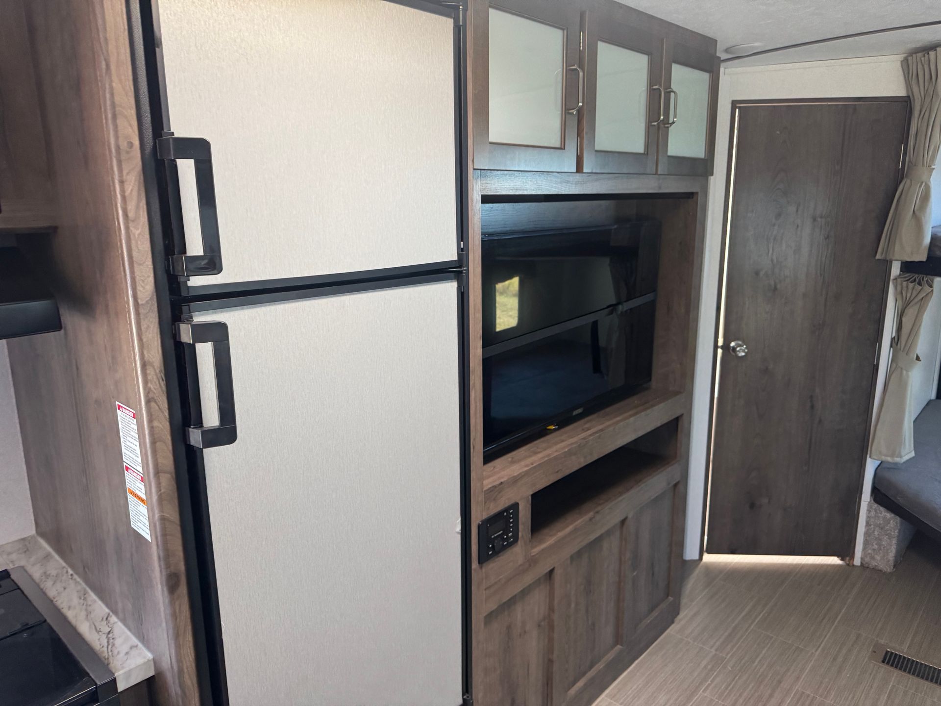 There is a refrigerator and a television in the room.