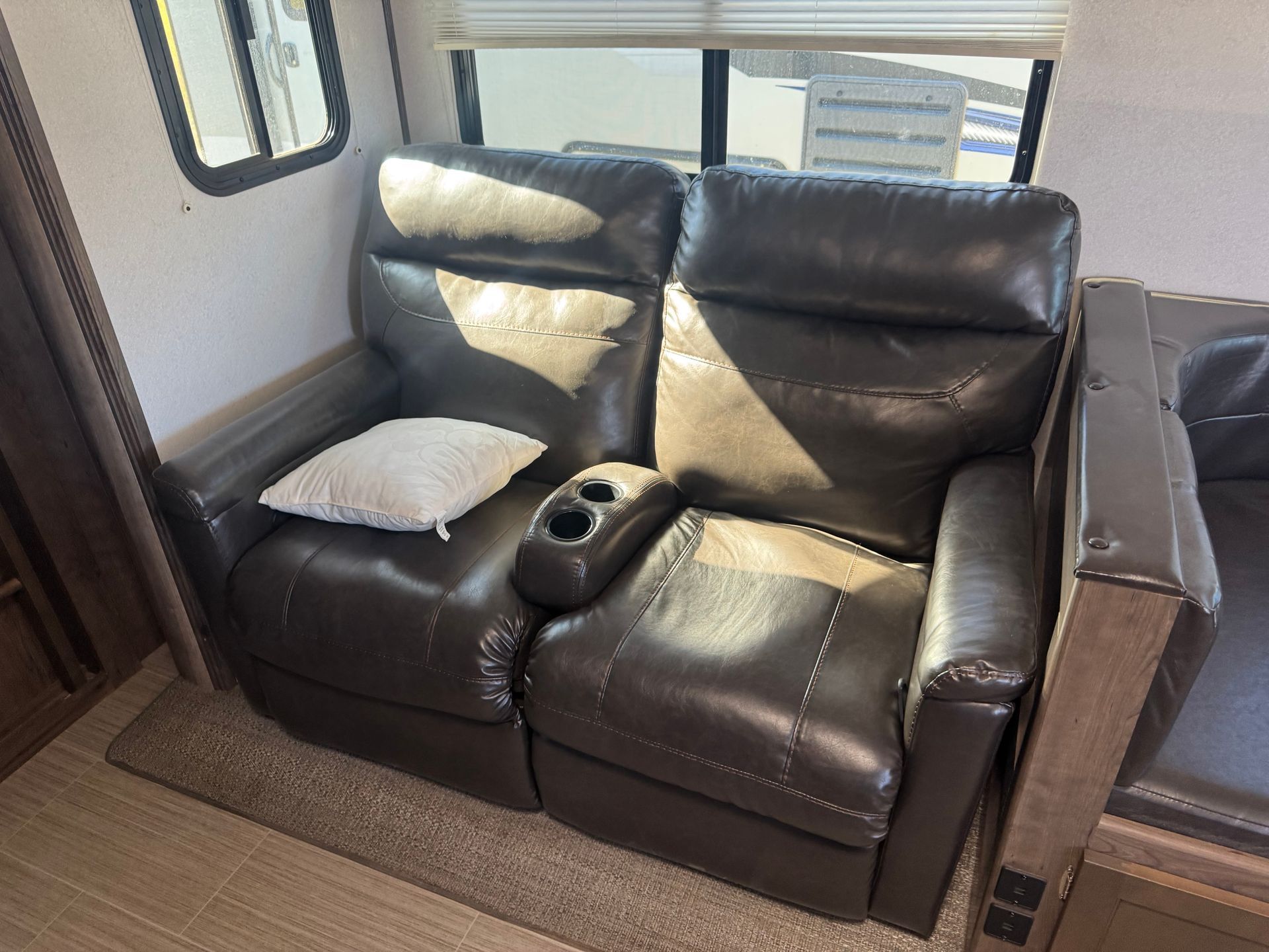 A couch in a rv with a pillow on it.
