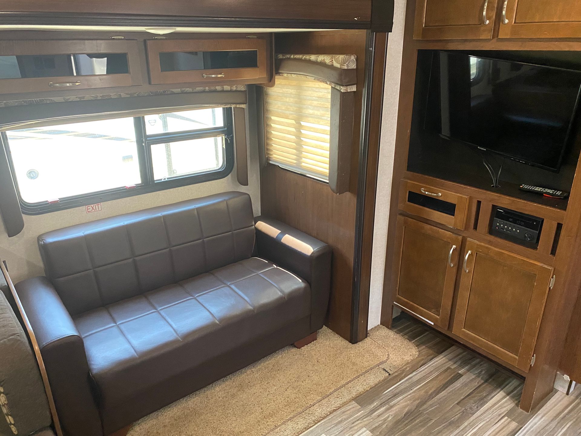 There is a couch in the middle of the room in a rv.