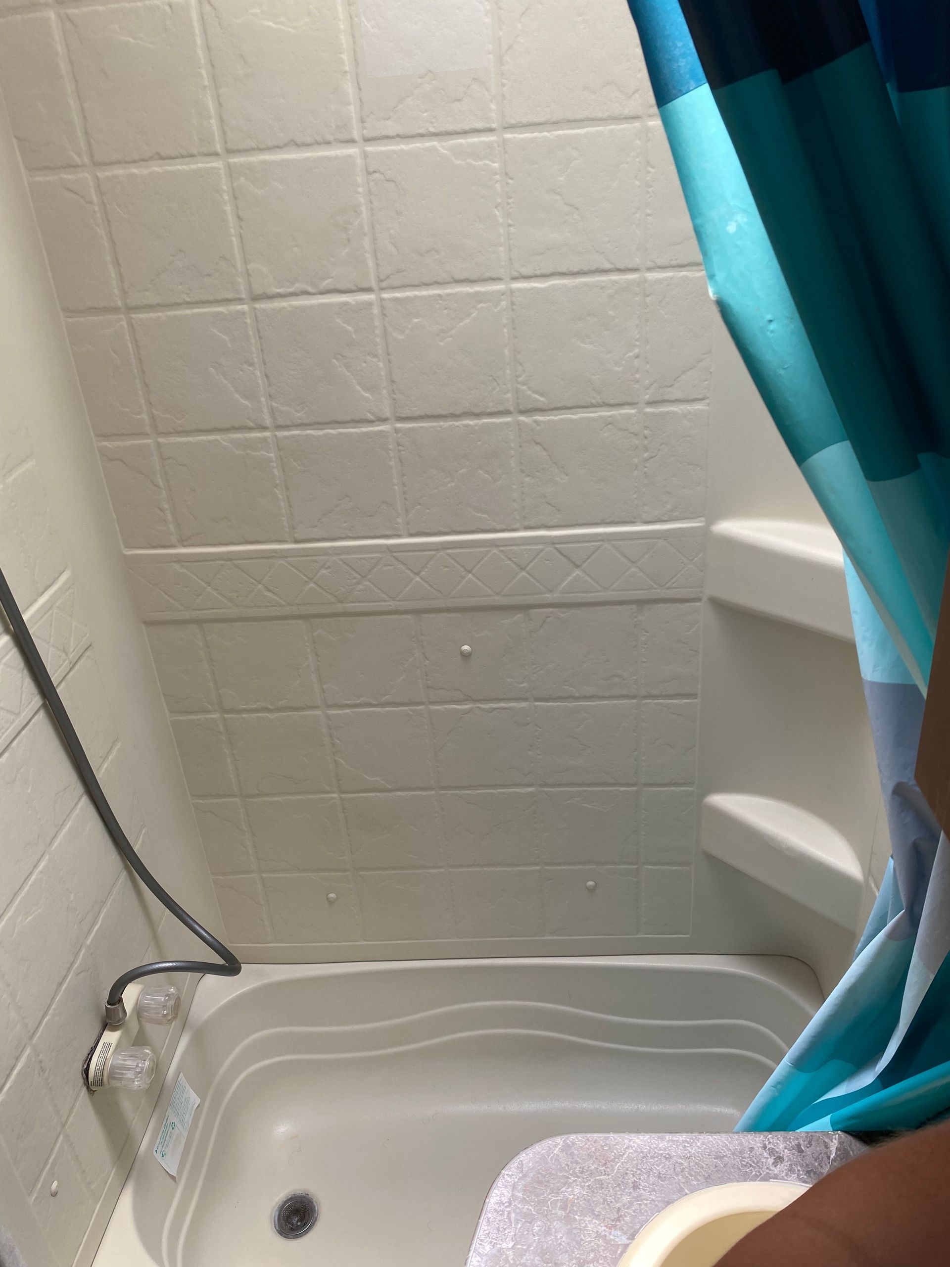 A bathroom with a blue shower curtain and a bathtub