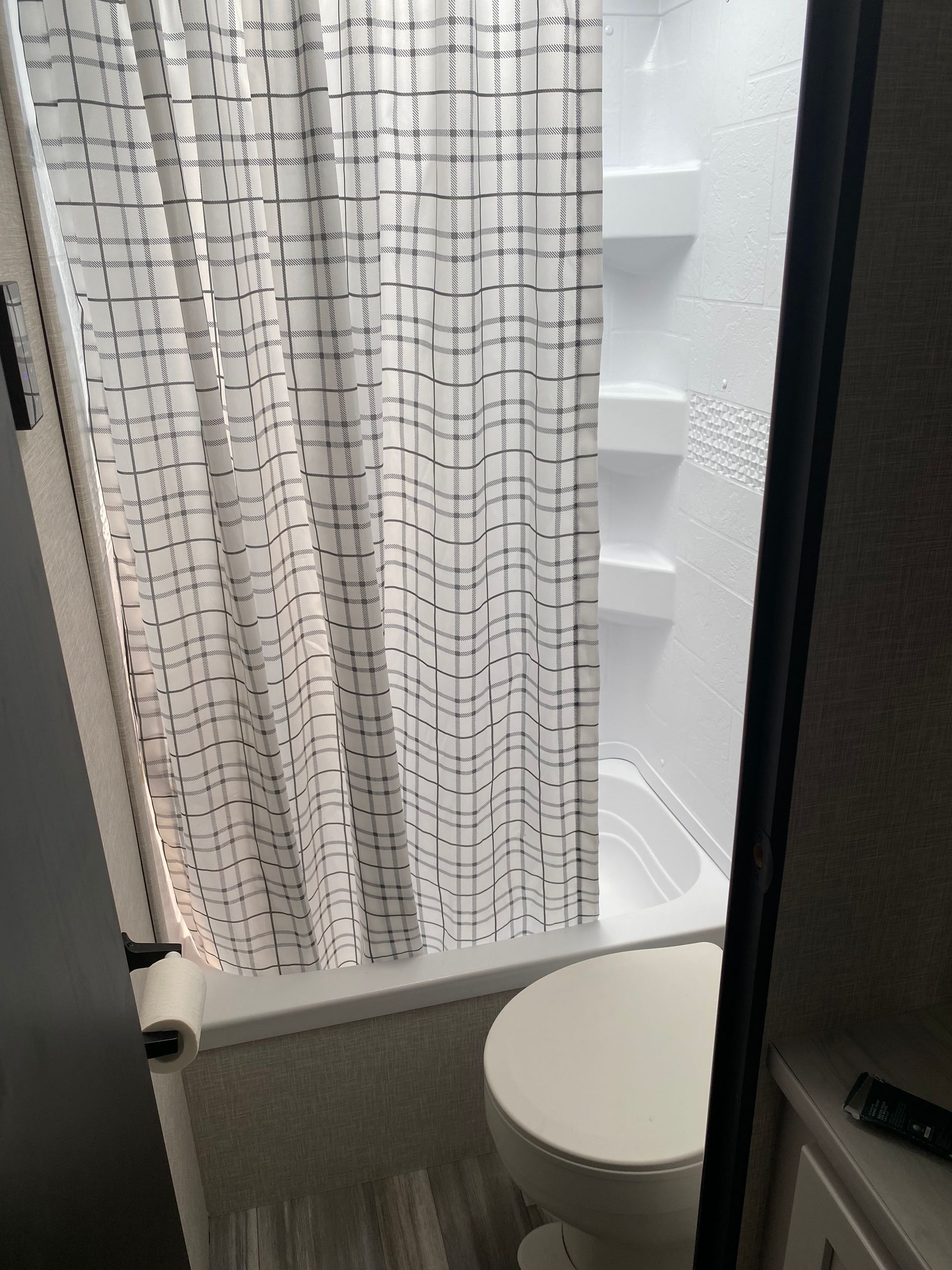 A bathroom with a shower curtain and a toilet