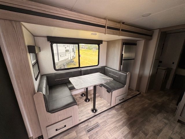 A rv with a table and benches in it.
