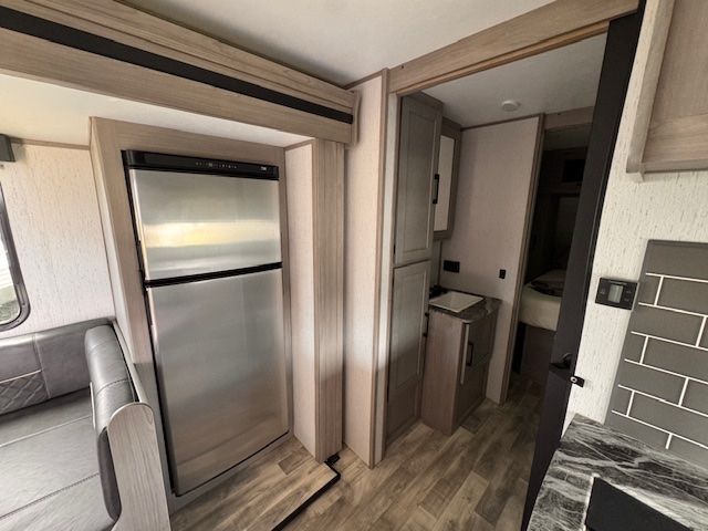 A rv with a refrigerator and a sink in it.