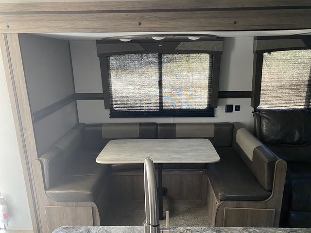 A dining area in a trailer with a table and benches.