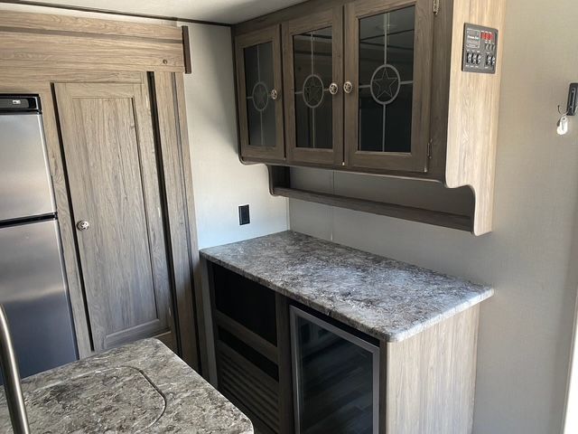 A kitchen with granite counter tops , cabinets and a refrigerator.