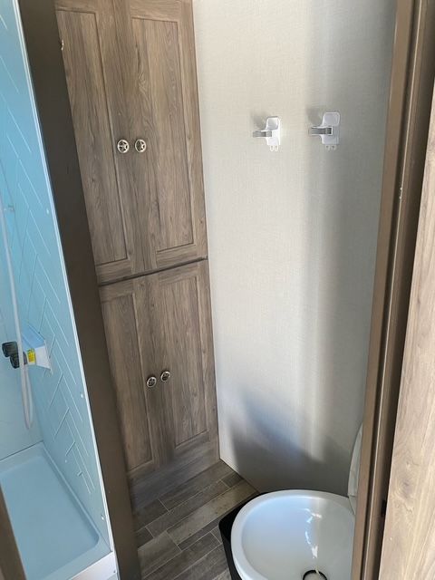 A bathroom with a toilet , sink and cabinets.