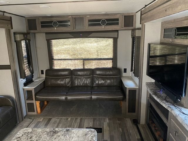 A living room in a rv with a couch and a television.