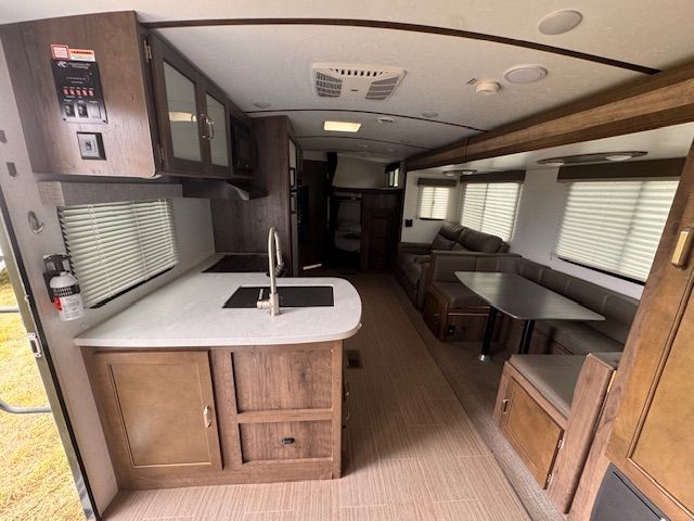 The inside of a trailer with a kitchen and dining area