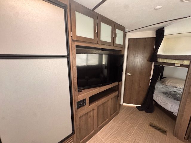 A bedroom with a bunk bed and a flat screen tv