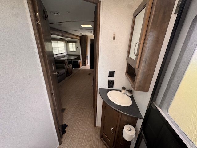 A bathroom with a sink and a mirror on the wall