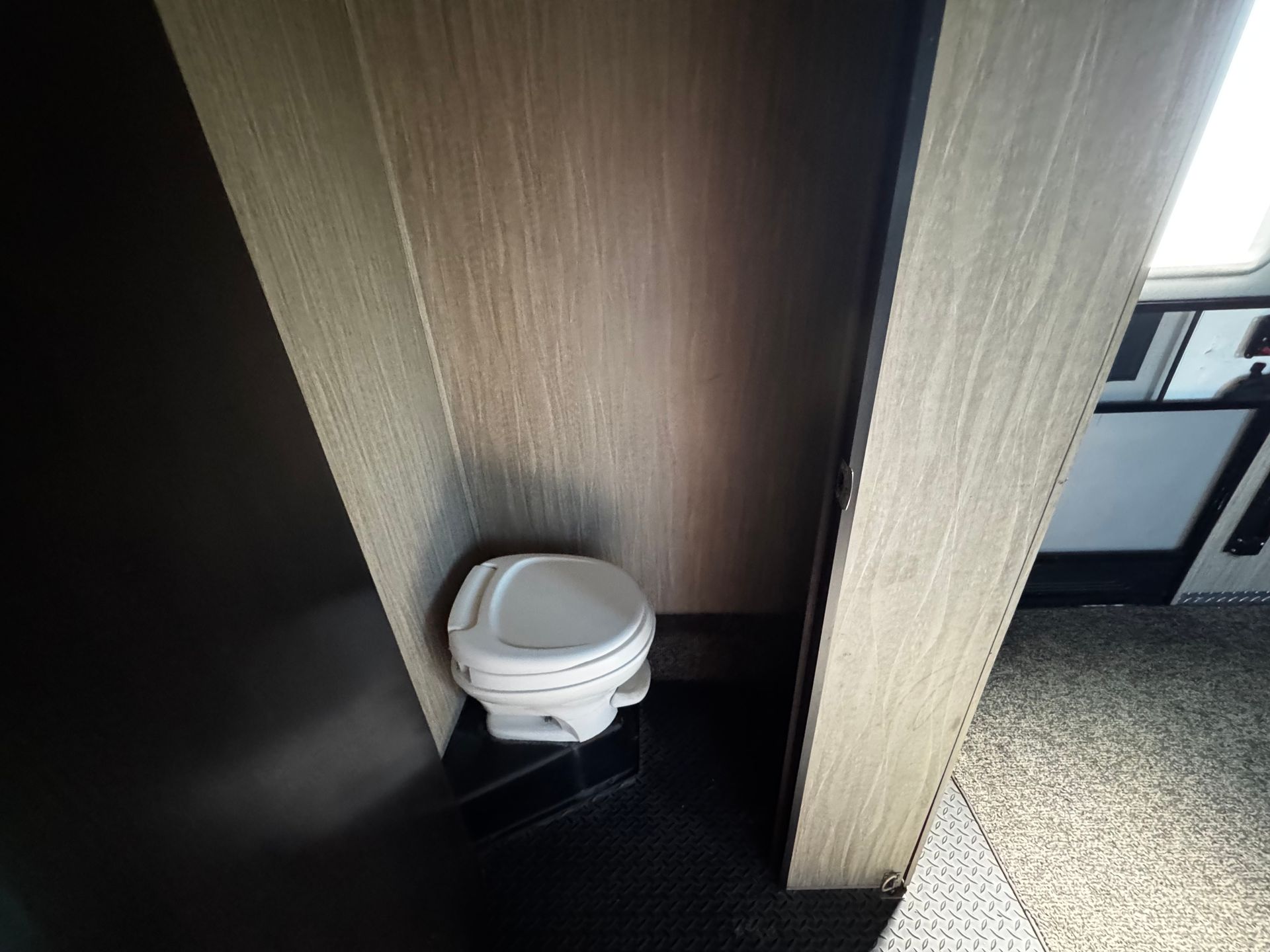 A toilet is sitting in a corner of a room.