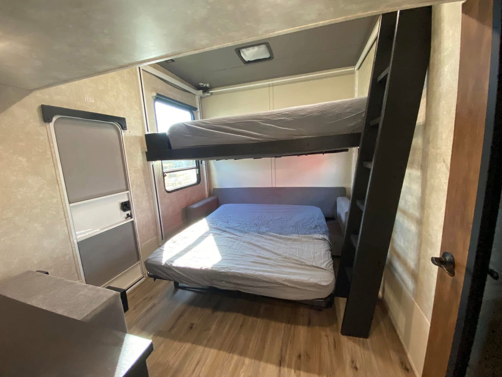 A bedroom with a bunk bed and a ladder.