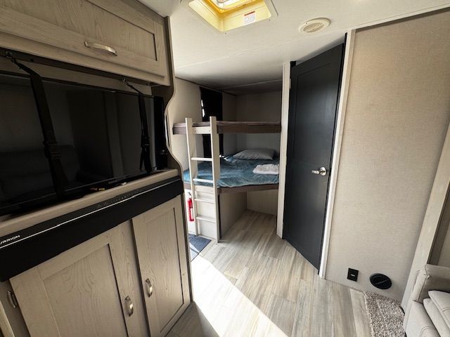 A rv with bunk beds and a flat screen tv