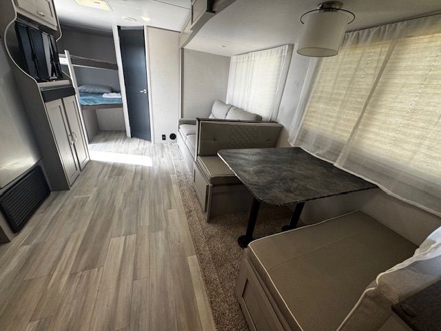 The inside of a rv with a table and couch.