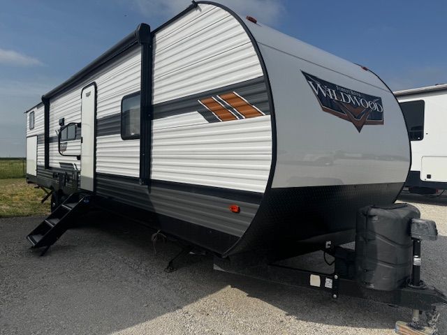 A white and black trailer is parked on the side of the road.