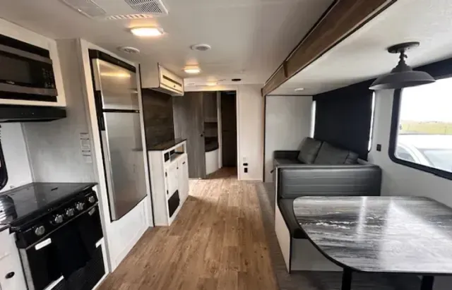 The inside of a rv with a table and a couch.